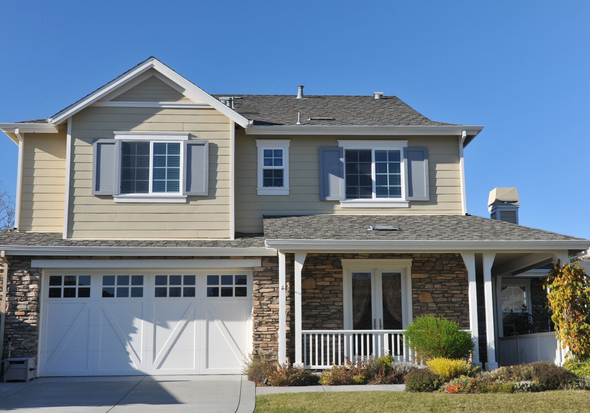 A modern two-story house with a garage and front porch.