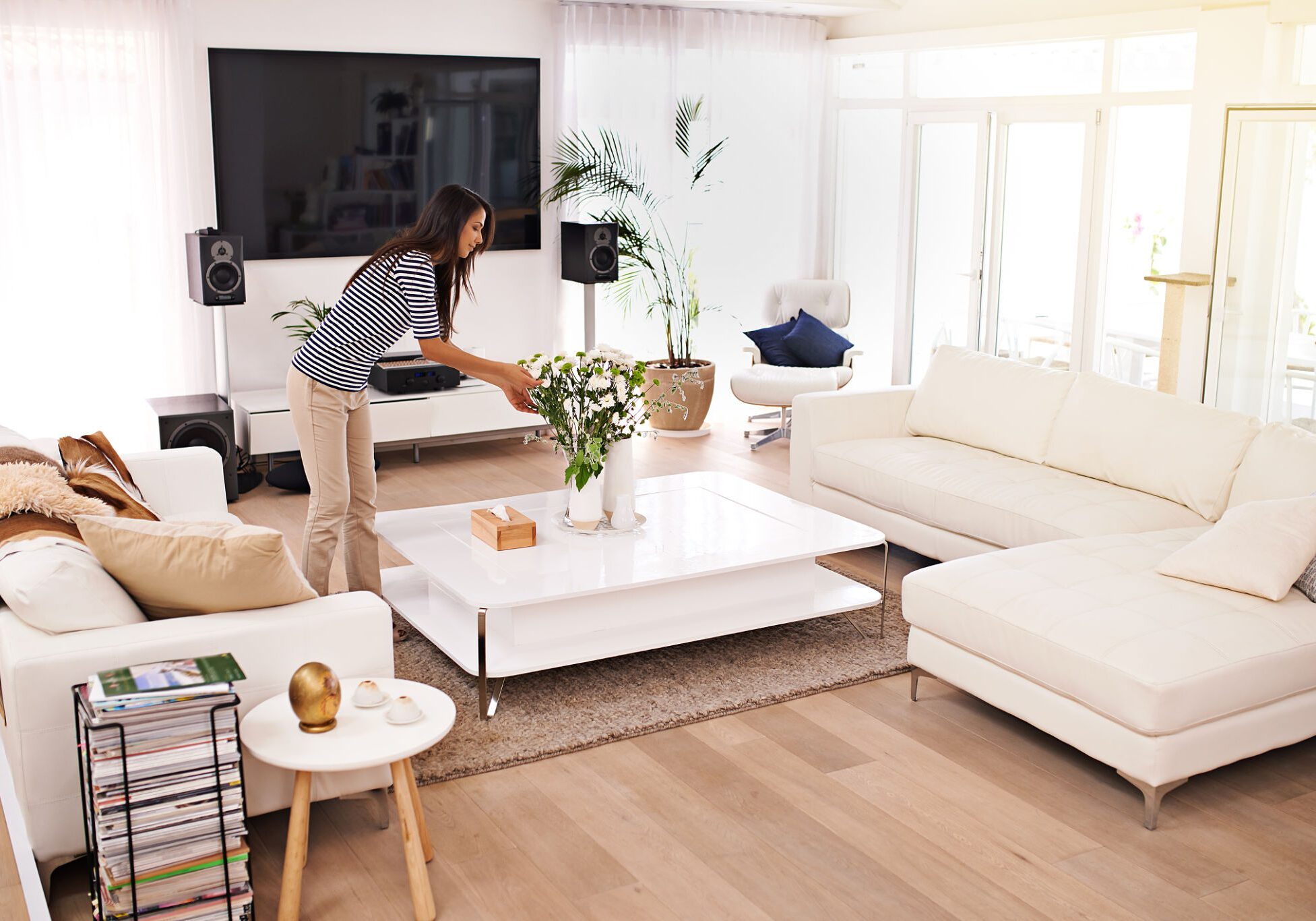 Woman arranging flowers in modern living room.
